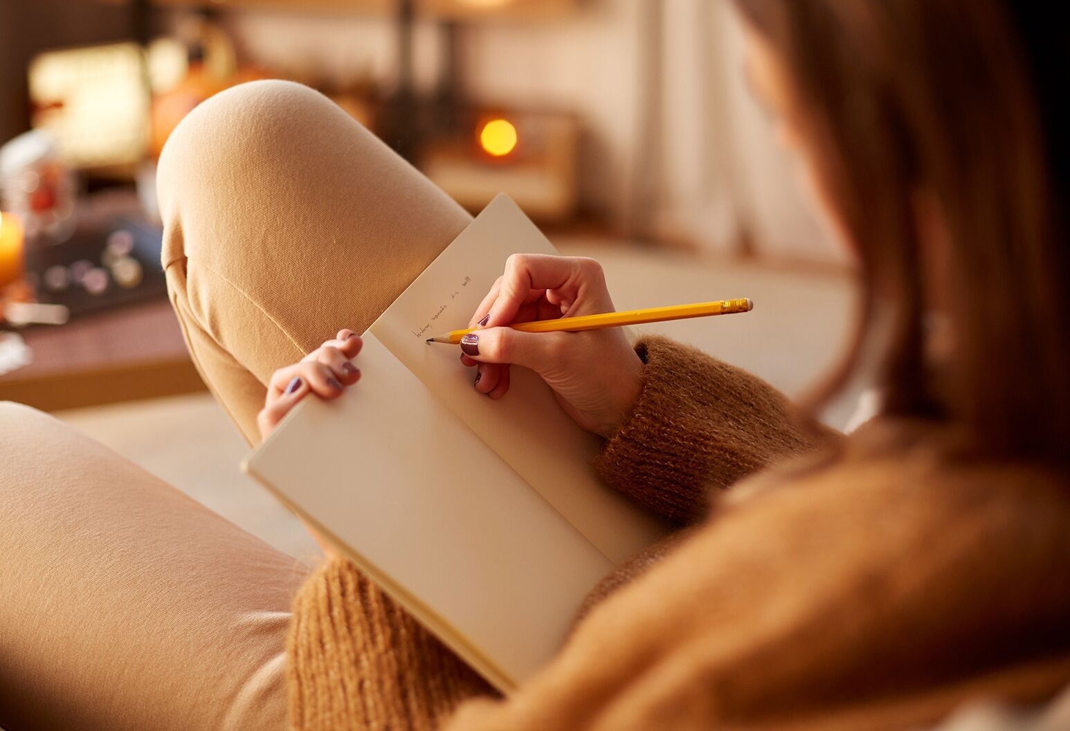 Mujer escribiendo en un cuaderno con luz cálida